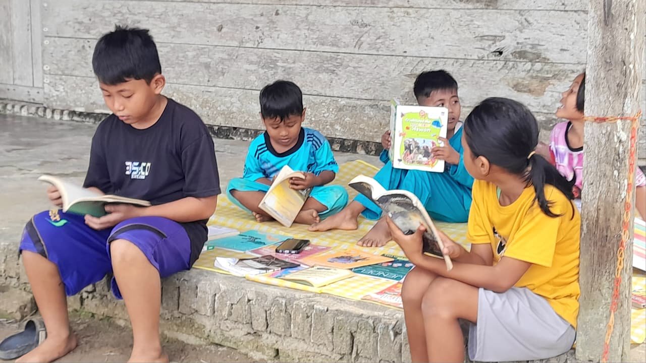 Aktivitas anak-anak membaca buku di Laman Baca Bandar Jaya Tanjung Jabung Timur Jambi.