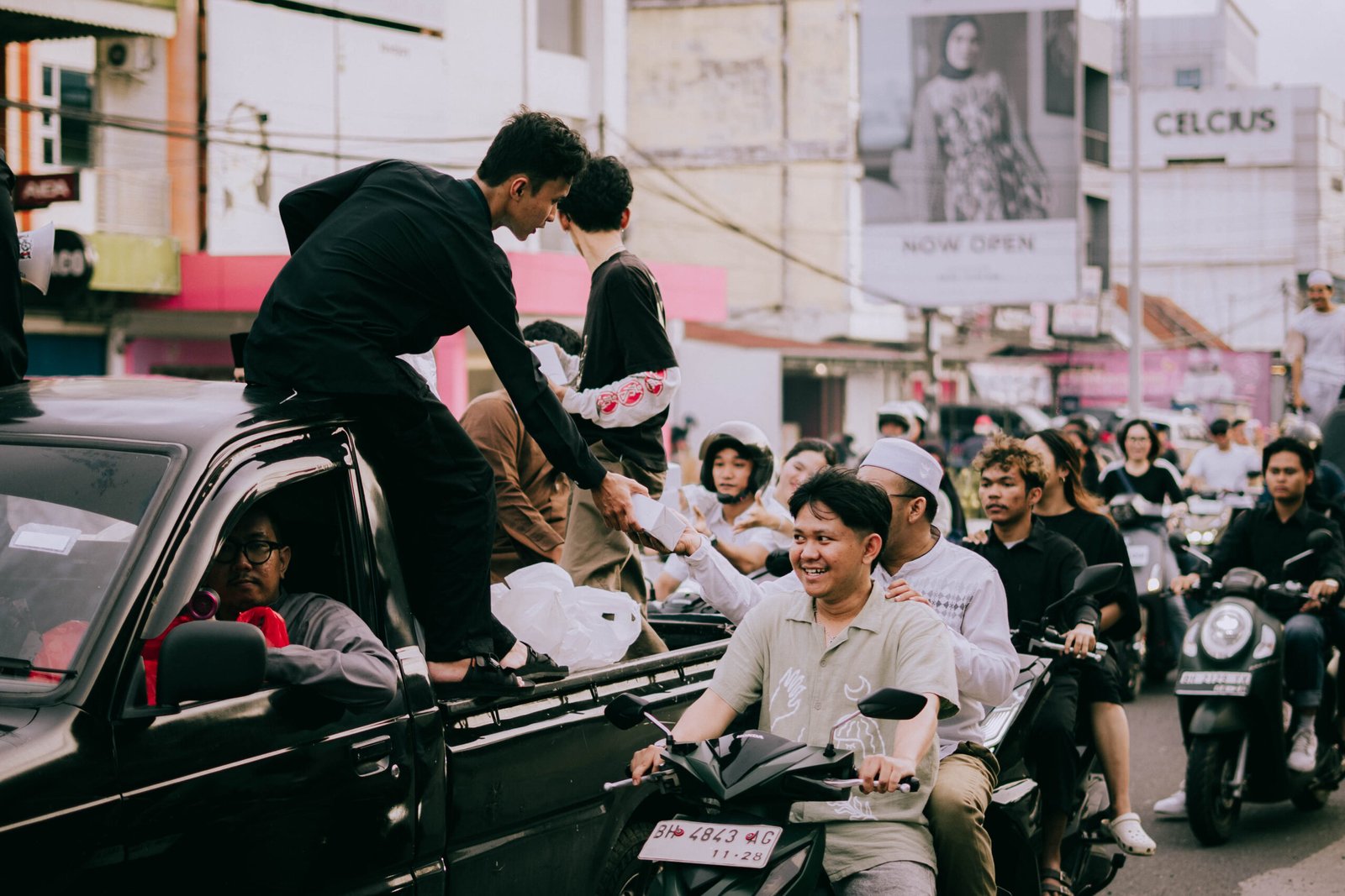 Pembagian takjil kepada pengguna jalan saat konvoi komunitas anak muda di Kota Jambi.